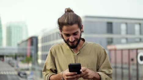 Hombre-Sonriente-Enviando-Mensajes-De-Texto-Por-Teléfono-Inteligente
